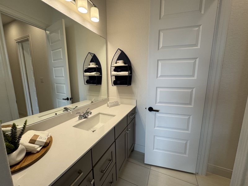 A sleek bathroom with a large mirror, elegant vanity, and modern lighting, offering a clean and stylish ambiance. A sleek bathroom with a large mirror, elegant vanity, and modern lighting, offering a clean and stylish ambiance.