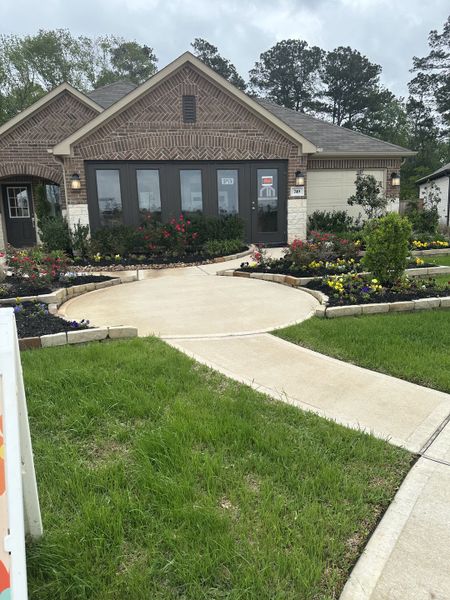 A charming brick home with landscaped gardens in Moran Ranch by M/I Homes (Willis, TX).