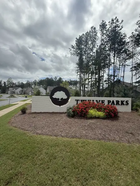 Welcome to Twelve Parks 55+ by Lennar in Sharpsburg, GA, boasting lush greenery and inviting community signage.