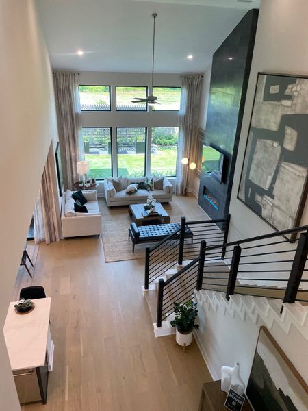 A modern living room with high ceilings, expansive windows, and stylish furnishings, offering a sleek, open atmosphere. A modern living room with high ceilings, expansive windows, and stylish furnishings, offering a sleek, open atmosphere.