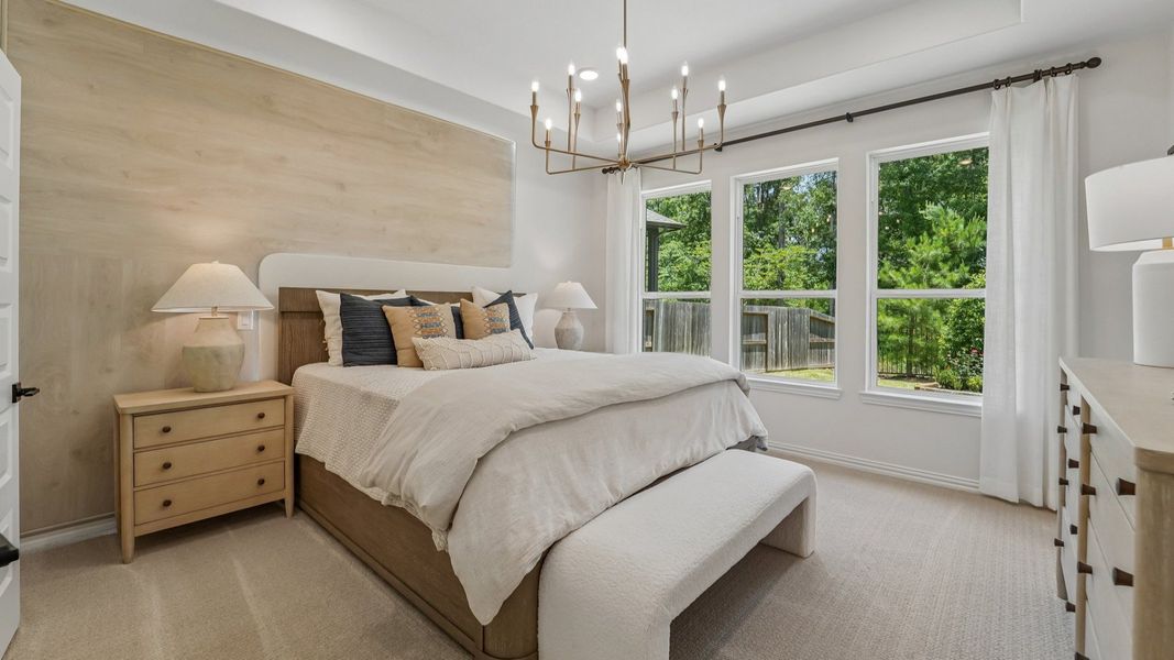 Experience refined elegance with a grand chandelier and expansive windows in The Woodlands Hills.