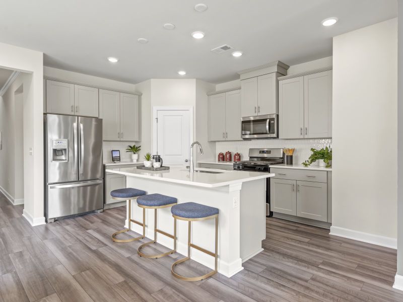 The spacious kitchen boasts stunning finishes, a large island and walk-in pantry.