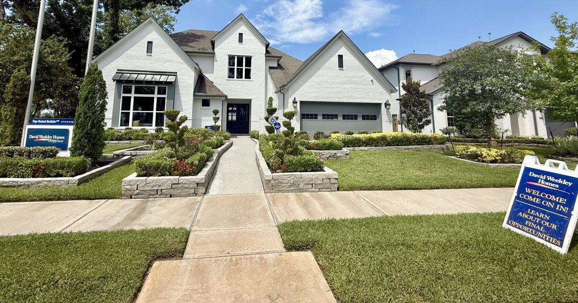 A beautiful white brick home with manicured landscaping in Sienna 65' Homesites by David Weekley Homes (Missouri City, TX). A beautiful white brick home with manicured landscaping in Sienna 65' Homesites by David Weekley Homes (Missouri City, TX).
