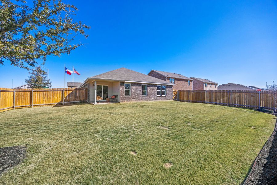 A house with a fence and a lawn in front of it. A house with a fence and a lawn in front of it.