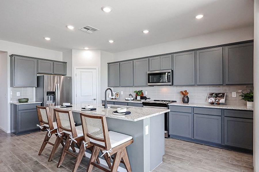 A kitchen with a table and chairs.