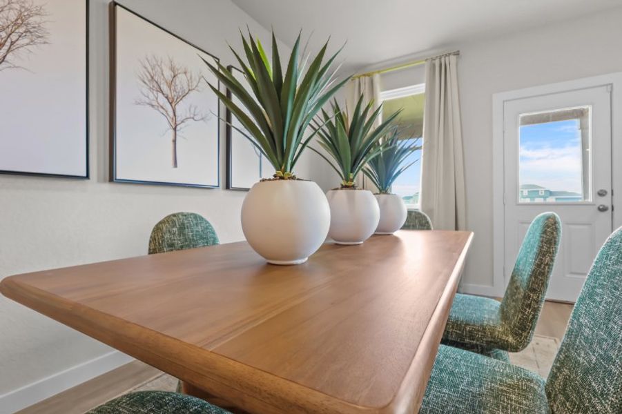 A table with a vase of plants. A table with a vase of plants.