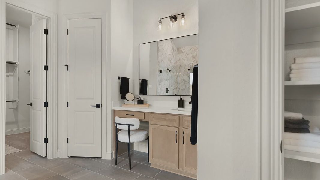 Owner’s bathroom features a true vanity detail with space for a chair, combining function and elegance.