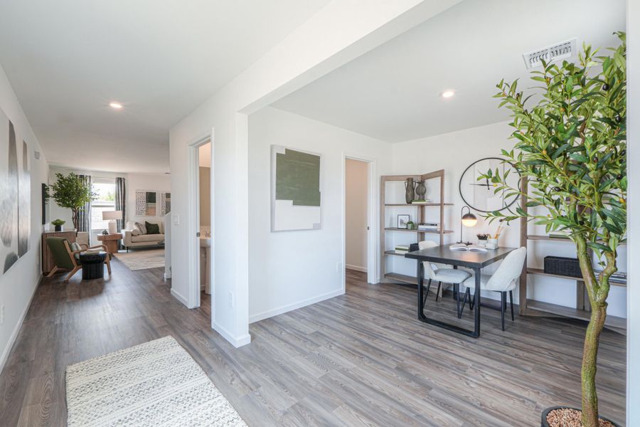 A living room with a table and chairs. A living room with a table and chairs.