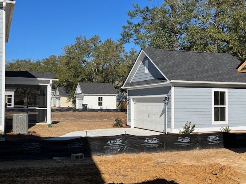 A charming gray home with detached garage and manicured landscape in Pineland Village by Center Park Homes (Summerville, SC).