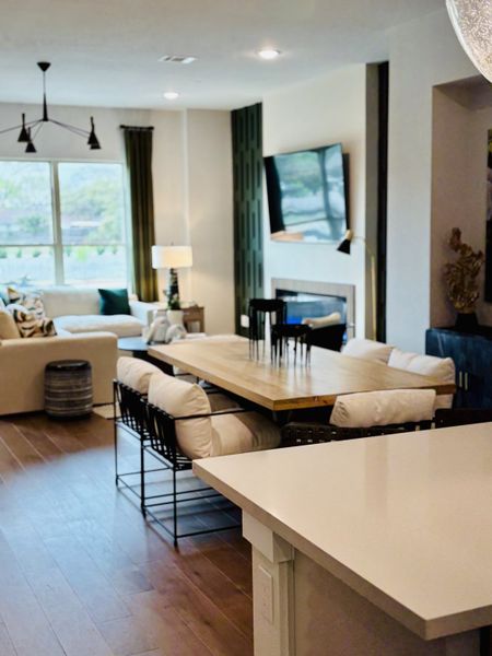 An elegant living space with modern furnishings, a cozy sofa, chic dining area, and sleek wood floors.