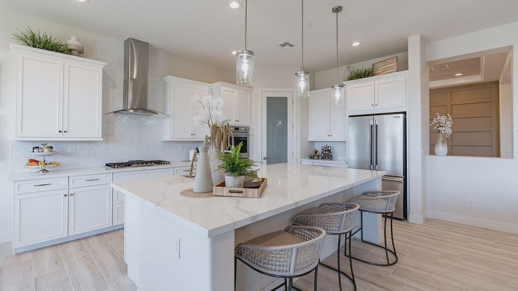 Windrose kitchen with quartz countertops, custom cabinetry, and elegant pendant lighting for sophisticated charm.