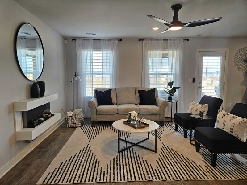 A cozy living room featuring a modern fireplace, stylish mirror, and chic furnishings with tasteful decor accents. A cozy living room featuring a modern fireplace, stylish mirror, and chic furnishings with tasteful decor accents.