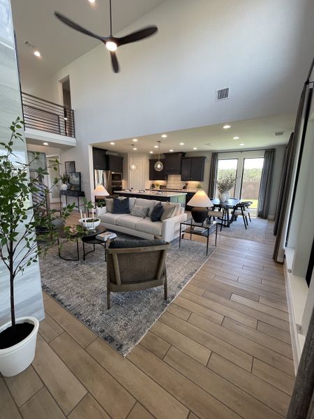 A modern open-concept living area with high ceilings, stylish furnishings, and large windows overlooking a serene outdoor view. A modern open-concept living area with high ceilings, stylish furnishings, and large windows overlooking a serene outdoor view.
