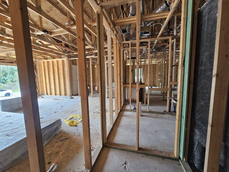 An under-construction home with exposed wood framing and open layout, awaiting completion for future customization.
