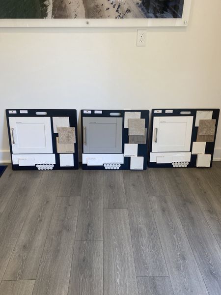 Elegant sample boards with cabinetry, tiles, and textures on sleek wood flooring. Elegant sample boards with cabinetry, tiles, and textures on sleek wood flooring.