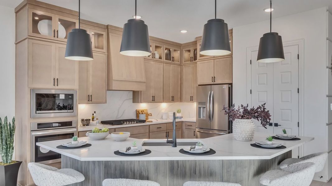 Elegant Creeks Crossing kitchen features marble counters, premium wood cabinets, and modern lighting.