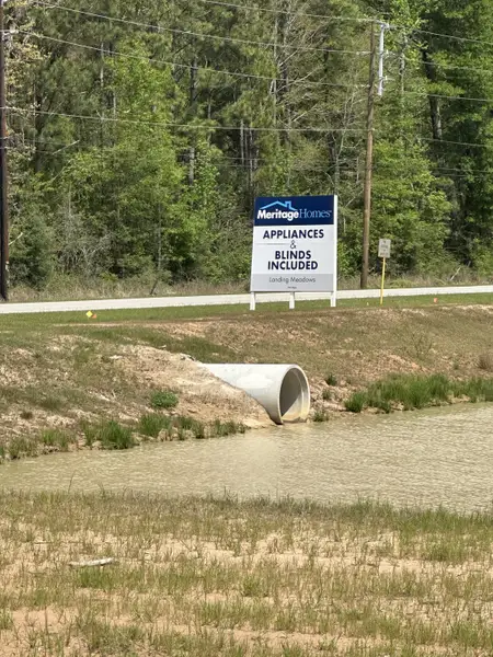 A scenic view by Landing Meadows by Meritage Homes, New Caney, TX, with lush greenery and serene waterbody. A scenic view by Landing Meadows by Meritage Homes, New Caney, TX, with lush greenery and serene waterbody.