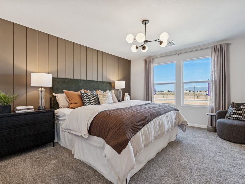 A bedroom with a bed and a chair.