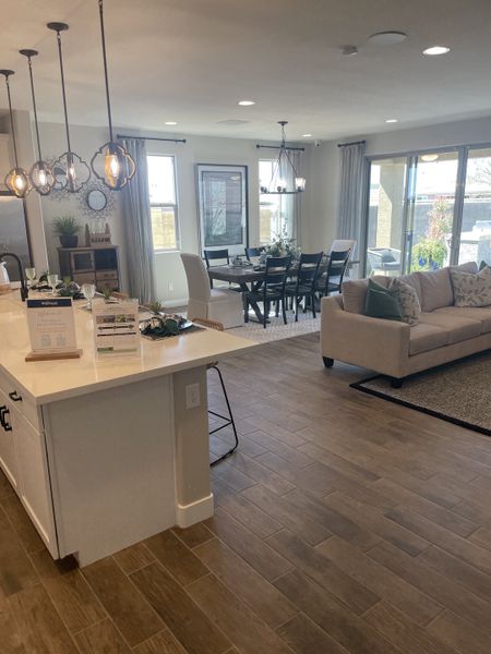 A spacious open-plan living area with a modern kitchen, elegant lighting, and a cozy dining space. A spacious open-plan living area with a modern kitchen, elegant lighting, and a cozy dining space.