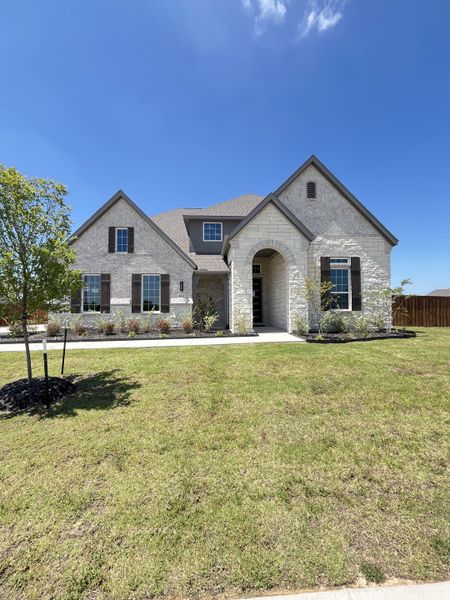 A stunning white brick home with shutters and a landscaped yard in Polo Ridge by GFO Home (Forney, TX). A stunning white brick home with shutters and a landscaped yard in Polo Ridge by GFO Home (Forney, TX).