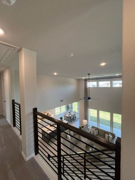 A modern open-concept space with high ceilings, a stylish balcony view, and abundant natural light.