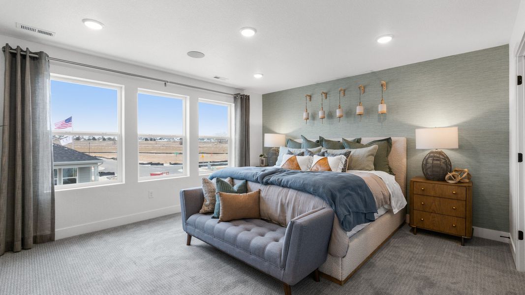 Spacious bedroom in Bloom, featuring panoramic windows, plush carpet, and elegant lighting accents.