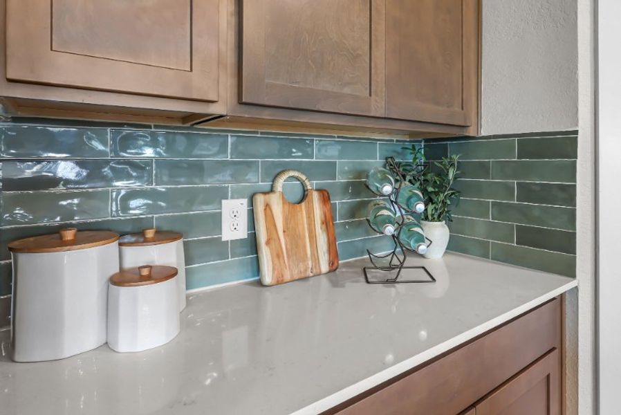 A kitchen counter with a plant and a vase of flowers. A kitchen counter with a plant and a vase of flowers.