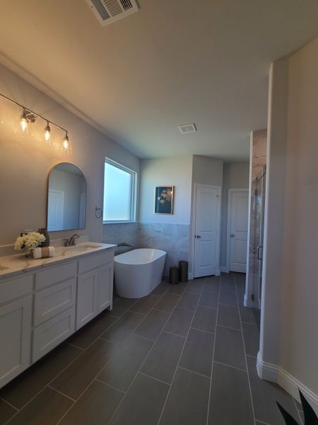A spacious bathroom with a freestanding tub, elegant double vanity, and soft lighting for a serene atmosphere.