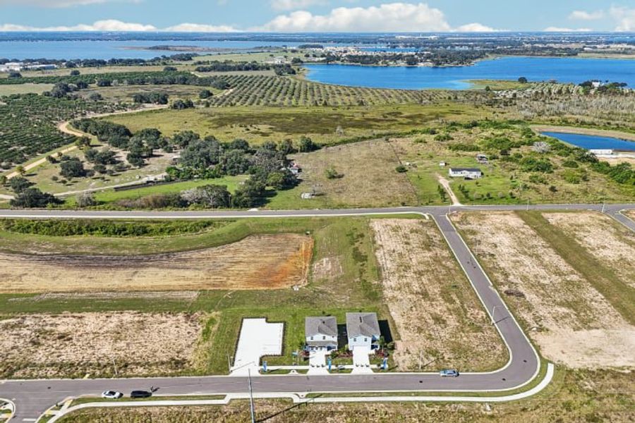 A road with a building and a body of water in the background.