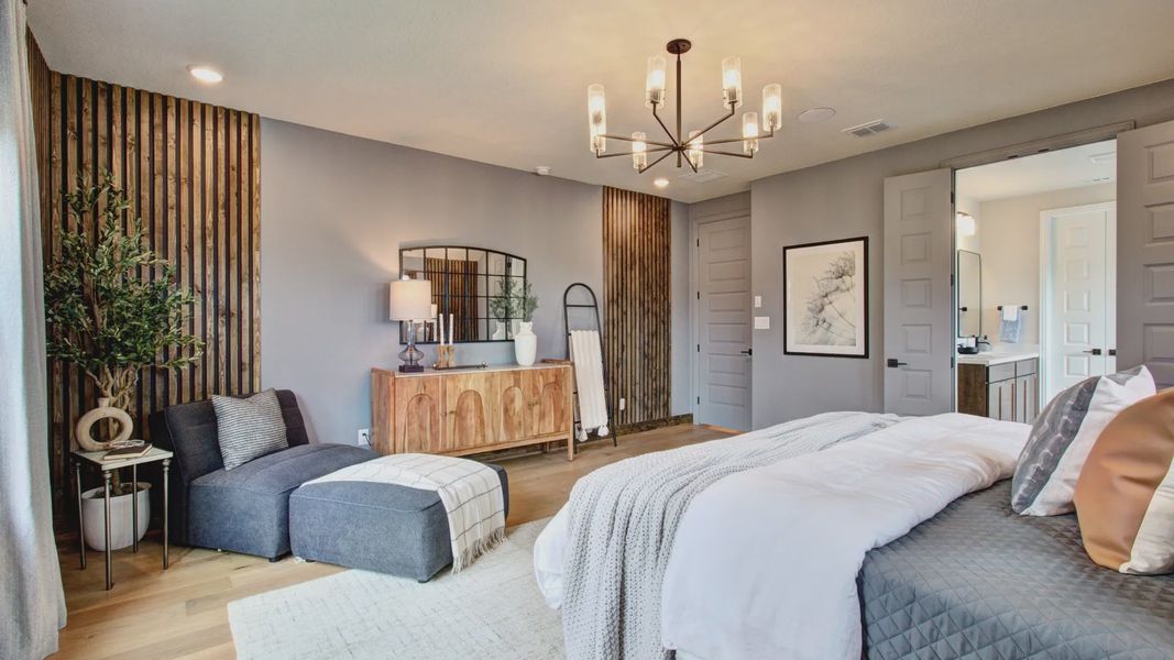 Elegantly crafted wood accents and a striking chandelier elevate this Sunflower Ridge master suite.