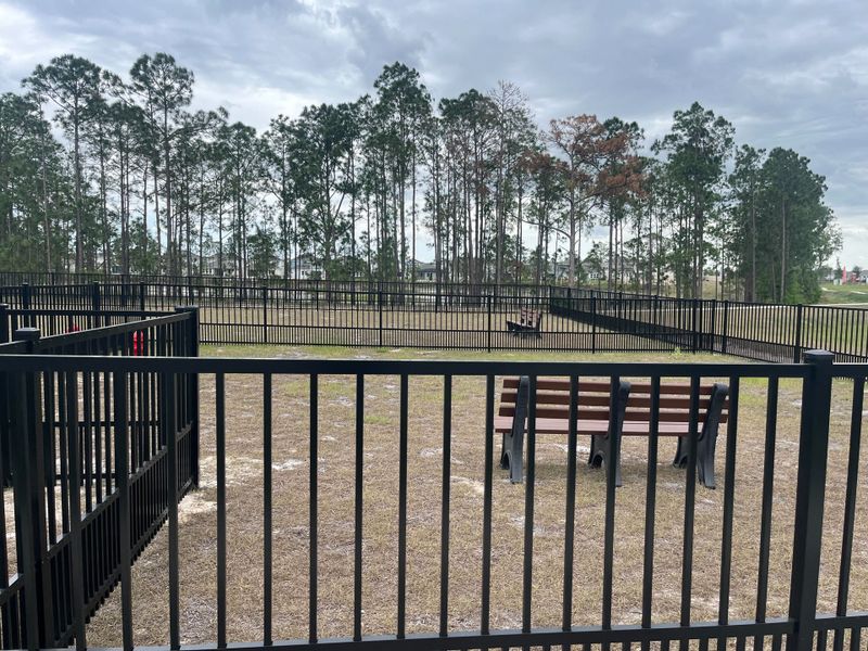 A fenced park area with benches amidst tall trees in Harvest at Ovation - Townhomes by Rockwell Homes (Winter Garden, FL). A fenced park area with benches amidst tall trees in Harvest at Ovation - Townhomes by Rockwell Homes (Winter Garden, FL).
