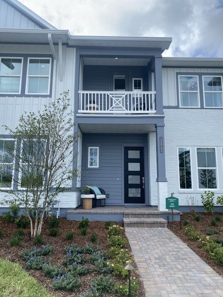 Charming gray and white townhouse with a cozy porch in Seven Pines 24' Rear Entry Townhomes by David Weekley Homes (Jacksonville, FL). Charming gray and white townhouse with a cozy porch in Seven Pines 24' Rear Entry Townhomes by David Weekley Homes (Jacksonville, FL).