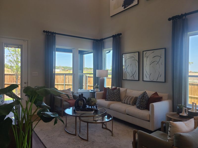 A modern living room filled with natural light, featuring elegant decor, cozy seating, and abstract wall art.