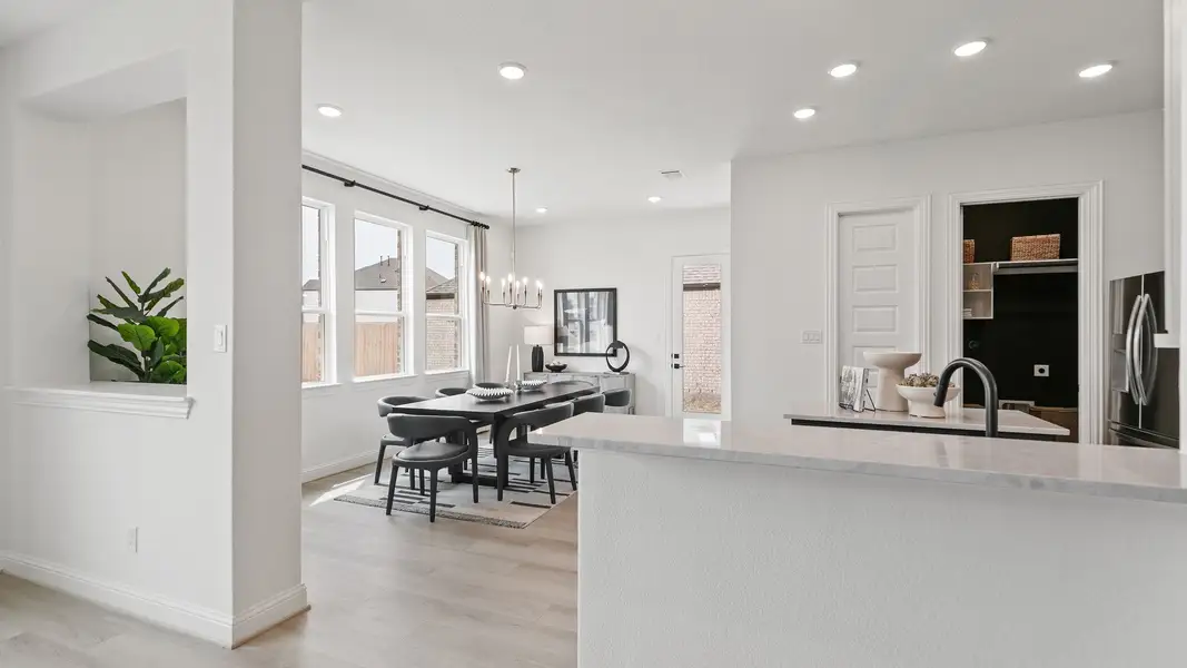 Luxurious open-plan dining with elegant chandelier and premium hardwood floors in Park at Eldridge, Houston.