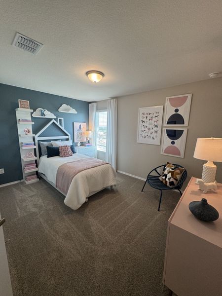 A cozy bedroom featuring a decorative wall headboard, soft carpeting, and stylish accents, creating a serene atmosphere. A cozy bedroom featuring a decorative wall headboard, soft carpeting, and stylish accents, creating a serene atmosphere.