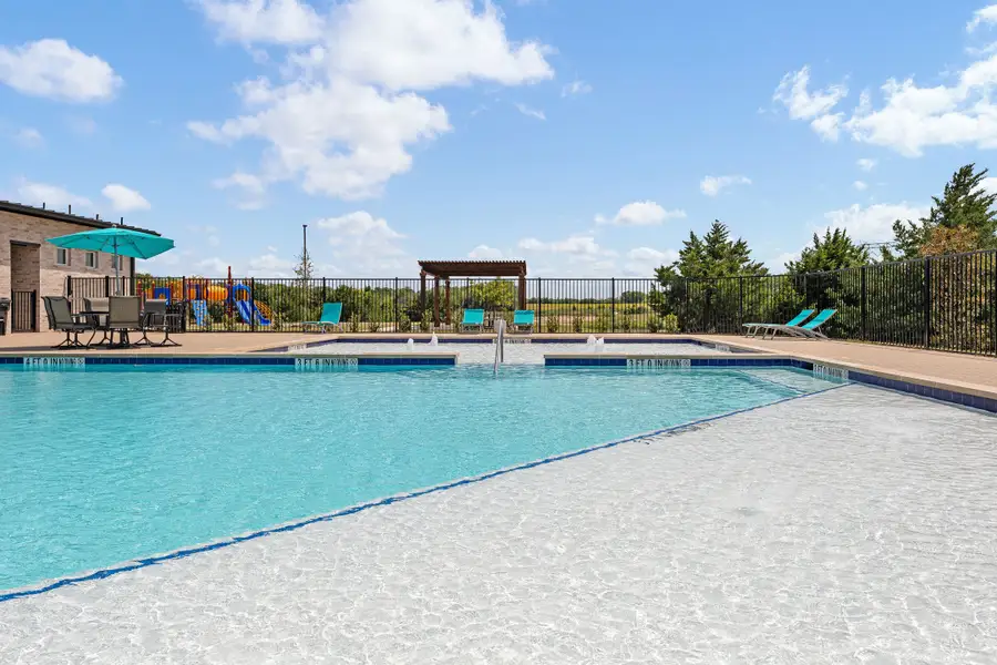 Community pool with water features, lounge chairs, pergola, and playground visible behind iron fence