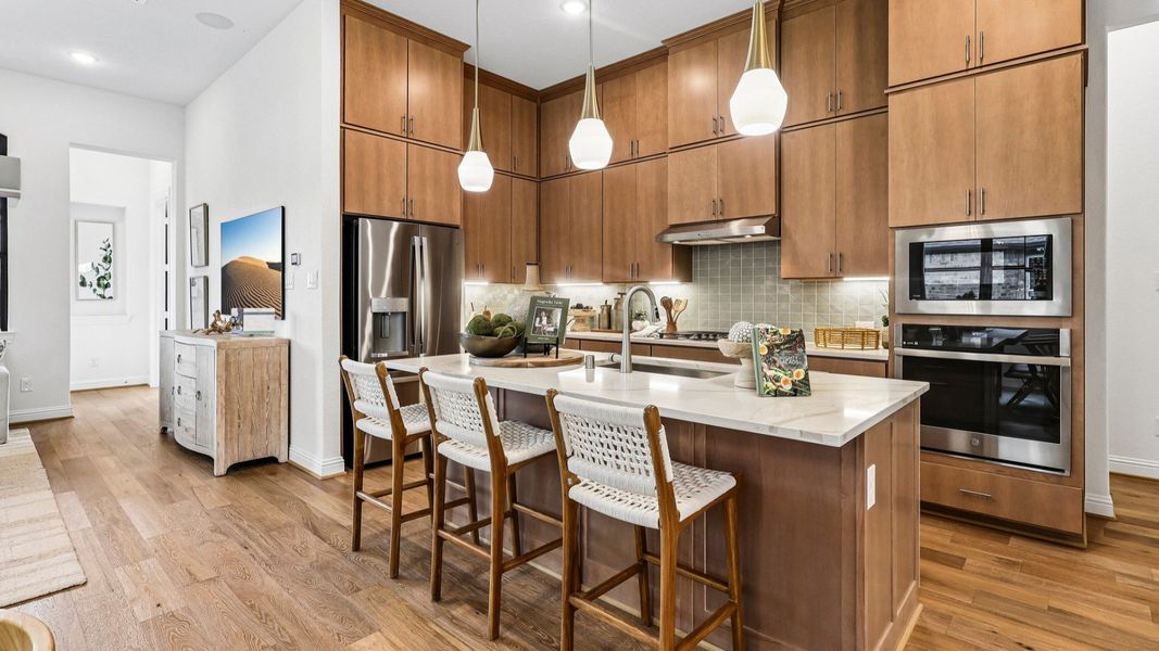 Elegant Sunterra kitchen boasts light wood cabinetry, sleek appliances, and a chic island centerpiece. Elegant Sunterra kitchen boasts light wood cabinetry, sleek appliances, and a chic island centerpiece.