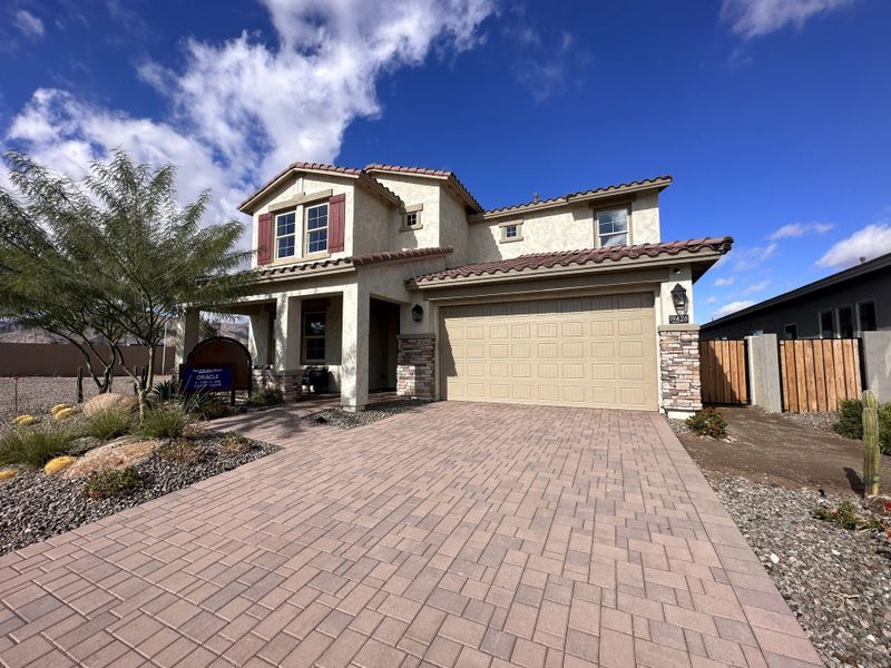 A beautiful two-story home with detailed stone accents and desert landscaping in IronWing at Windrose by David Weekley Homes (Litchfield Park, AZ).