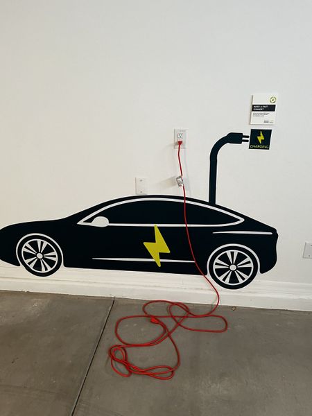 A garage wall decal features an electric vehicle charging station, blending function with a creative design.