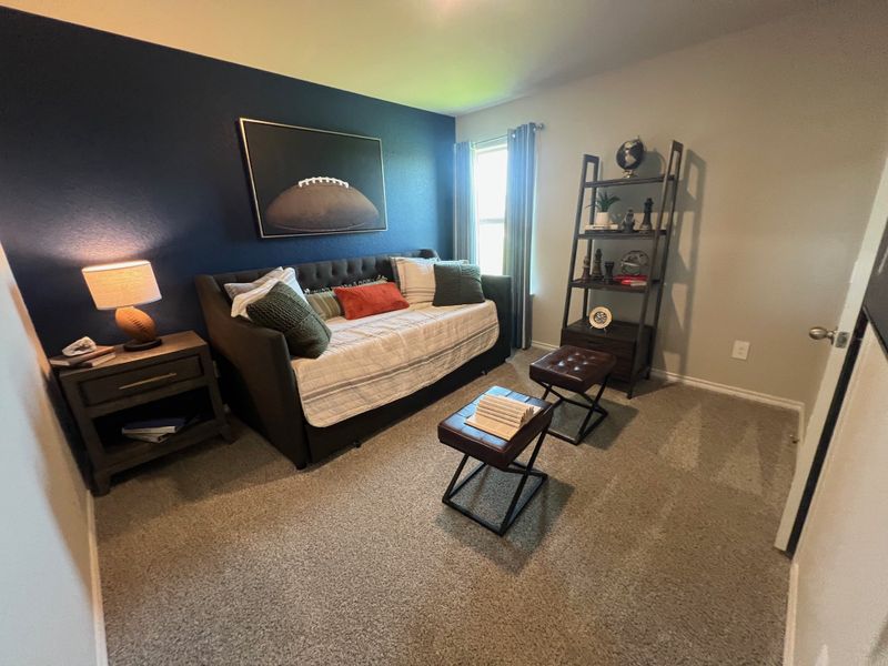 A cozy room with a dark accent wall, stylish daybed, and open shelving. Decor is sports-themed with modern touches. A cozy room with a dark accent wall, stylish daybed, and open shelving. Decor is sports-themed with modern touches.