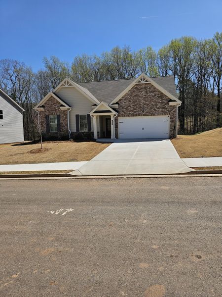 A charming brick home with a spacious driveway in Hellen Valley by McKinley Homes, Braselton, GA.