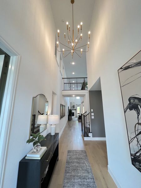 Elegant hallway featuring modern lighting, sleek console, and artful decor enhancing an inviting atmosphere.