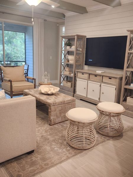 A cozy living room with rustic furniture, a neutral palette, and modern decor, featuring a large TV and natural light. A cozy living room with rustic furniture, a neutral palette, and modern decor, featuring a large TV and natural light.