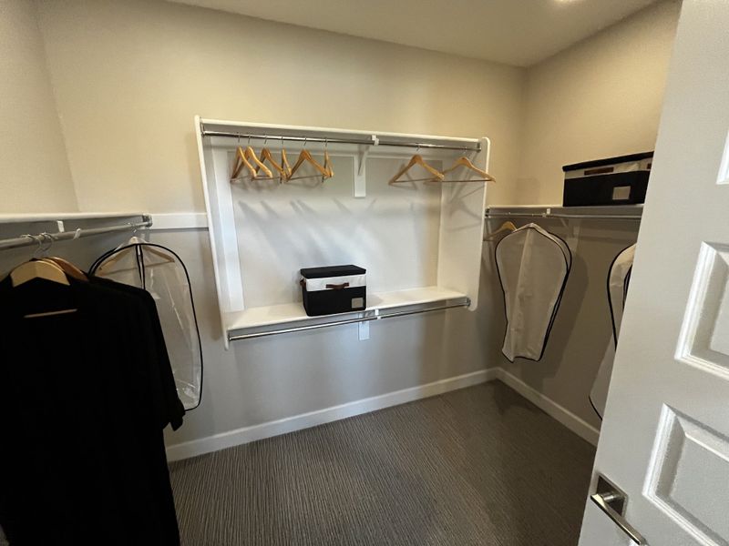 Large pantry with white shelving, organized storage baskets, and neatly arranged dishes.