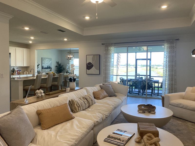 A spacious living room with a cozy white sofa, modern decor, and a view of the patio and dining area. A spacious living room with a cozy white sofa, modern decor, and a view of the patio and dining area.