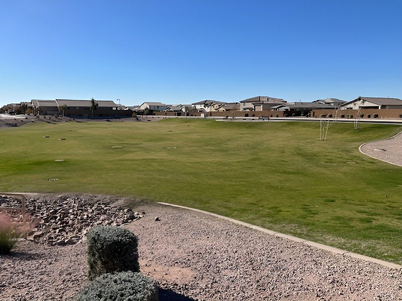 Expansive green space with distant homes in The Lakes at Rancho El Dorado by Century Communities (Maricopa, AZ).