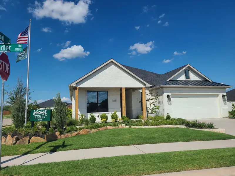 A charming white brick home with a landscaped yard in University Park at Northpointe by Wyndham Custom Homes (Denton, TX).