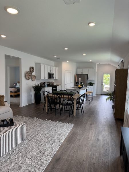 A modern open-concept living space with sleek kitchen, dining area, and wood flooring creating a cozy, inviting atmosphere.