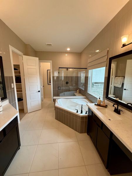A sleek bathroom featuring a spacious tub, double vanity, and warm lighting for a cozy ambiance. A sleek bathroom featuring a spacious tub, double vanity, and warm lighting for a cozy ambiance.