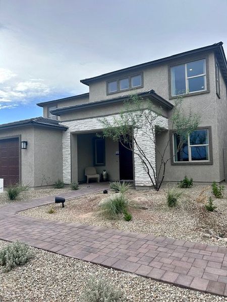 Modern two-story home with stone accents and desert landscaping in The Grove at El Cidro by William Ryan Homes (Goodyear, AZ).